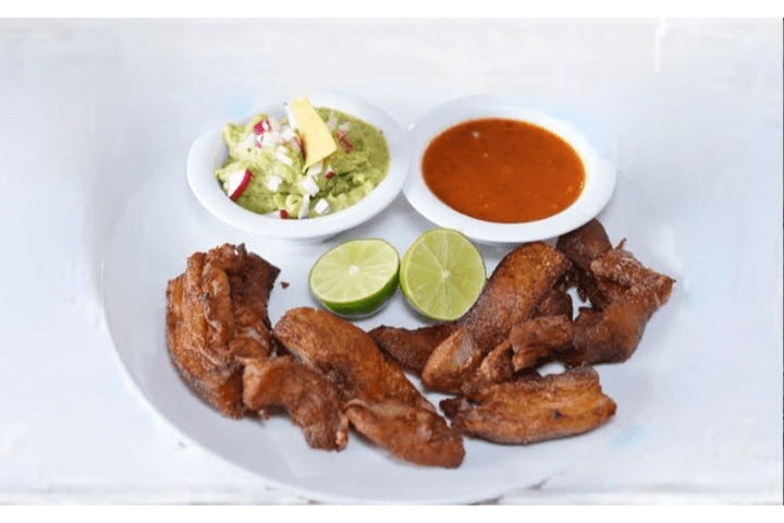 Fried pork chicharrónes with guacamole & hot sauce